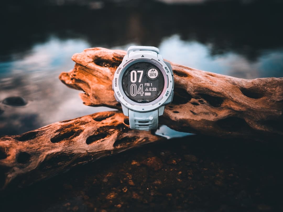 Garmin GPS running watch resting on driftwood by water