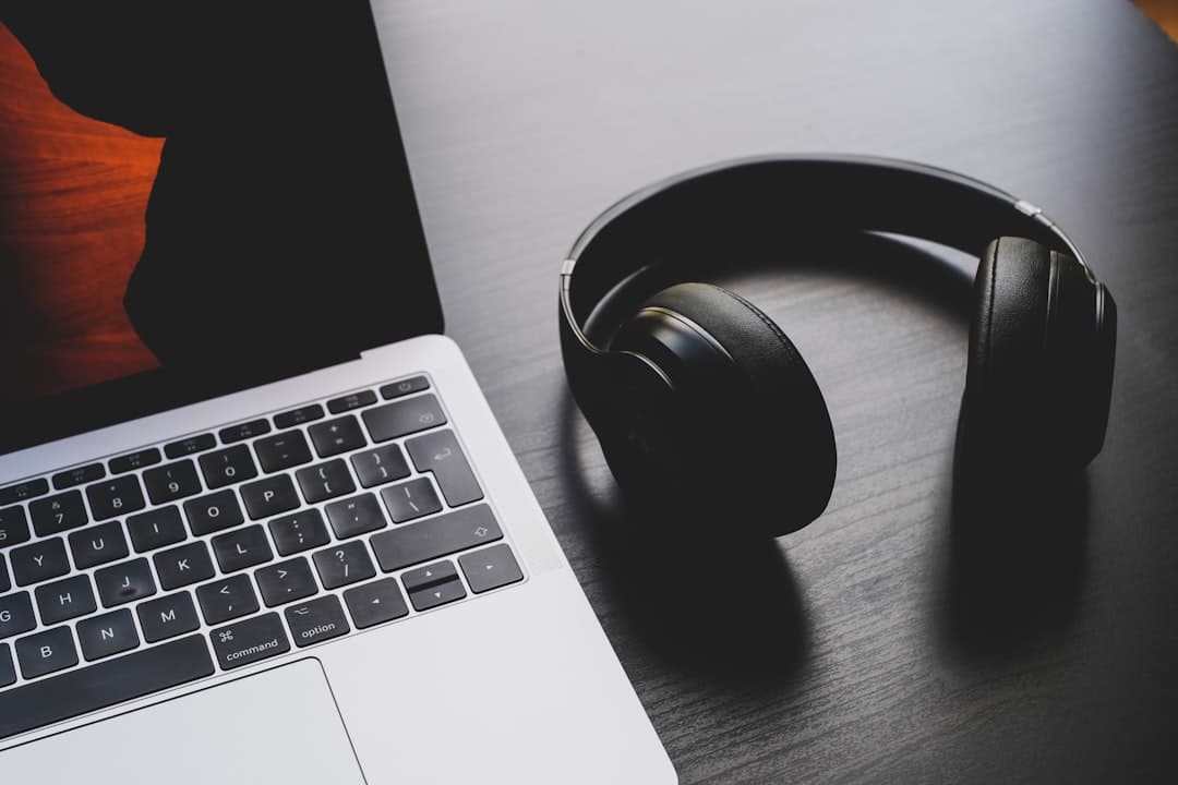 Wireless noise-cancelling headphones beside a laptop