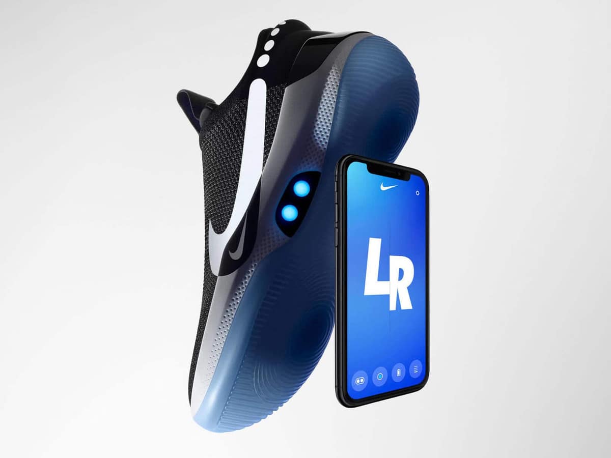 The Nike Adapt BB self-lacing basketball shoe beside a phone running the Nike Adapt app showing left and right controls