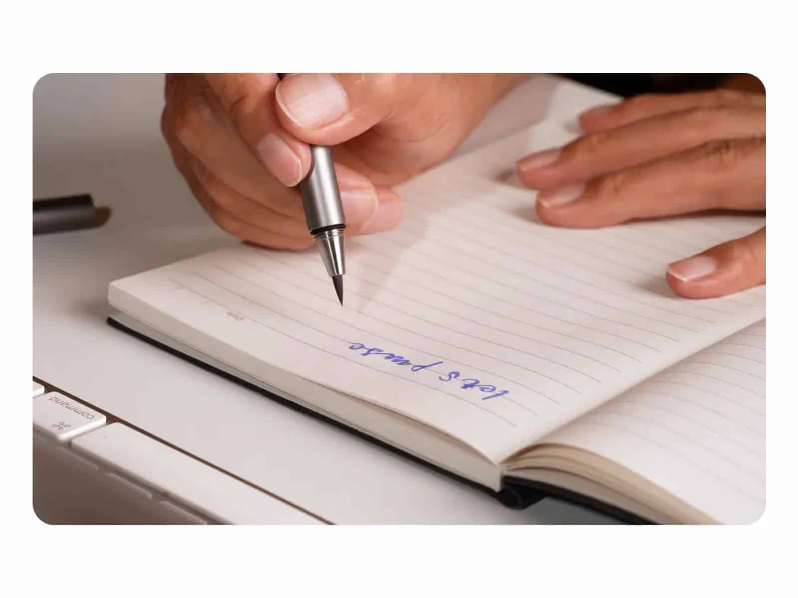 STILL STILL pen laid horizontally on its teardrop cap groove with the tip suspended above the desk