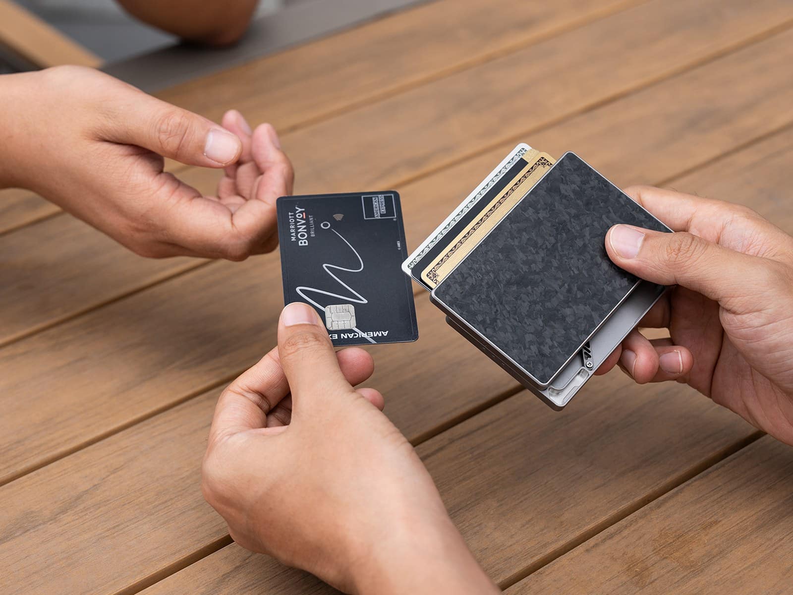 Titaner Verso Handing over a card at the table, with the rest fanned in the wallet
