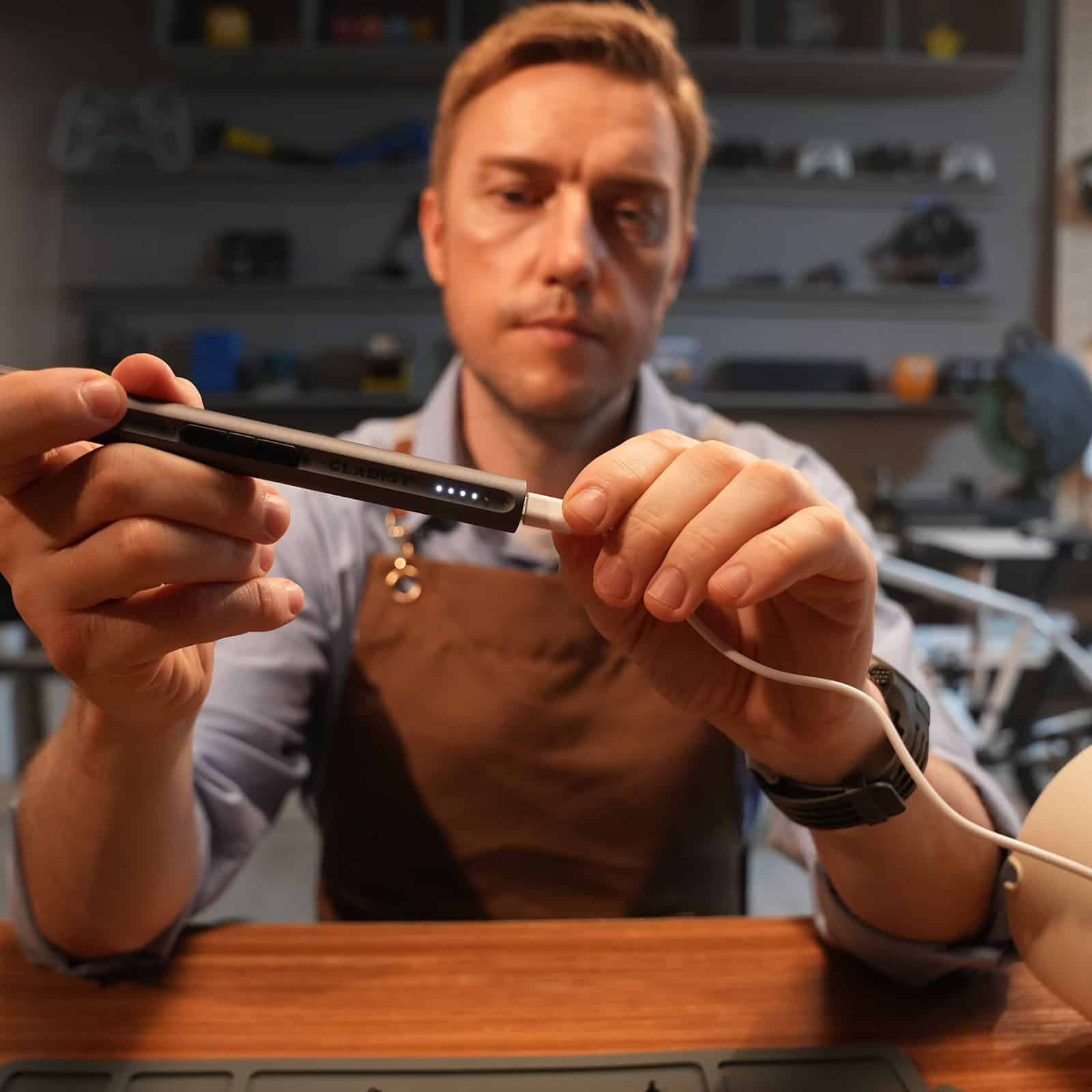 Man in an apron using the Cladist Titan on a wristwatch at a workbench