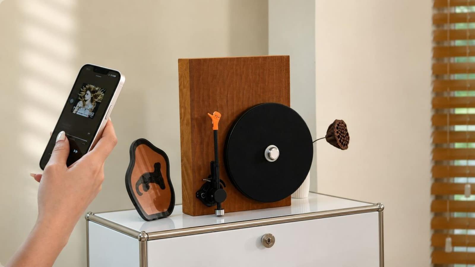 Hand holding a phone streaming music over Bluetooth to an ECHOV DY040 standing upright on a white sideboard