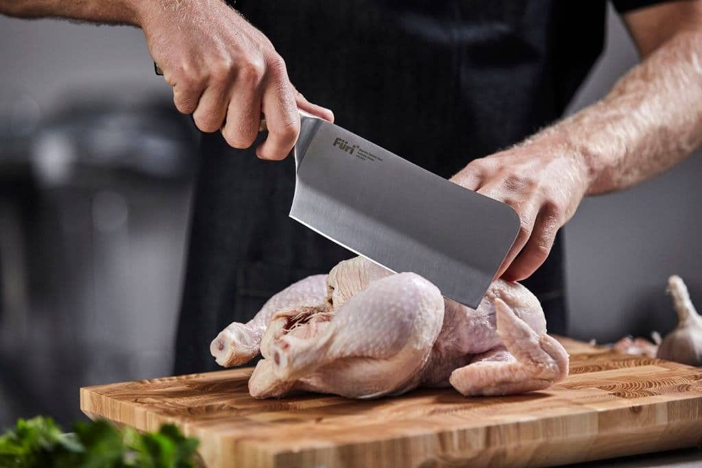 Breaking down a whole chicken with a Furi cleaver on a timber board