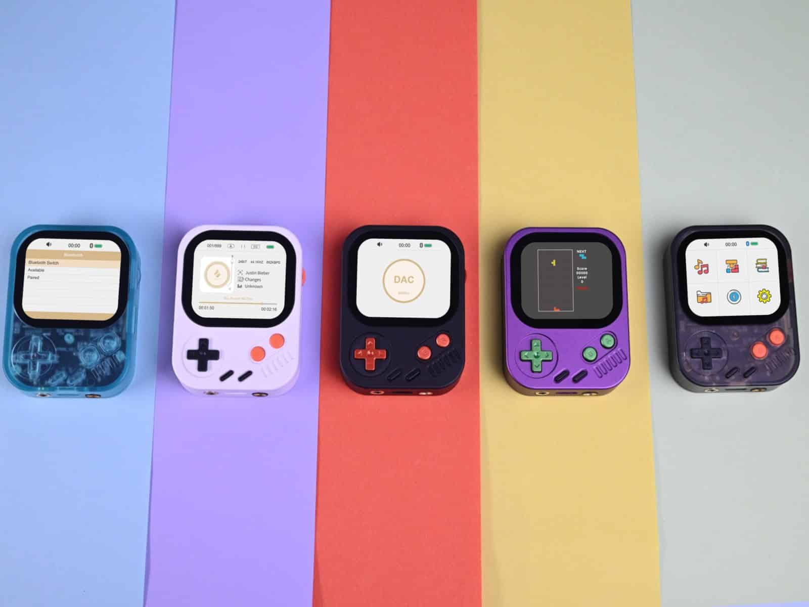 Five Hidizs AP30 Music Boy units lined up against vertical bands of pastel colour, showing the white, black, red, purple and translucent finishes