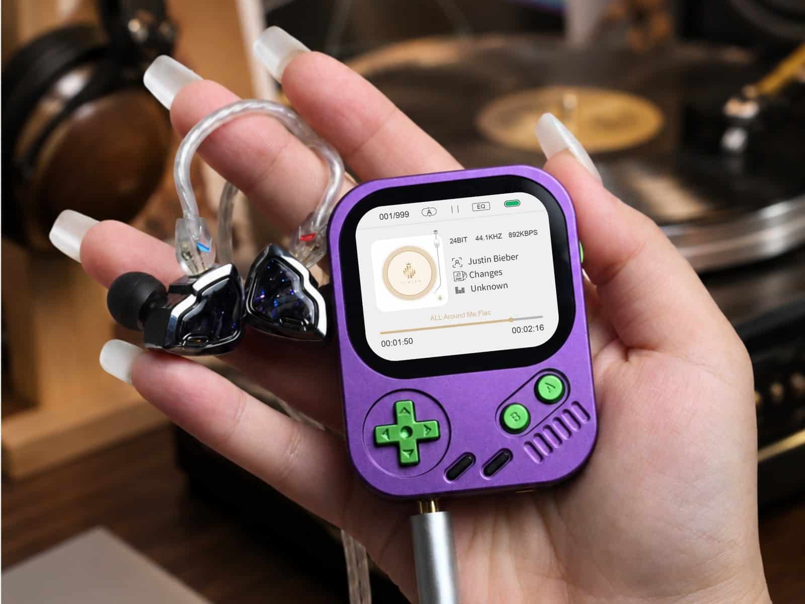 Hand holding a purple Hidizs AP30 Music Boy with in-ear monitors attached, in front of a hi-fi system and record shelf