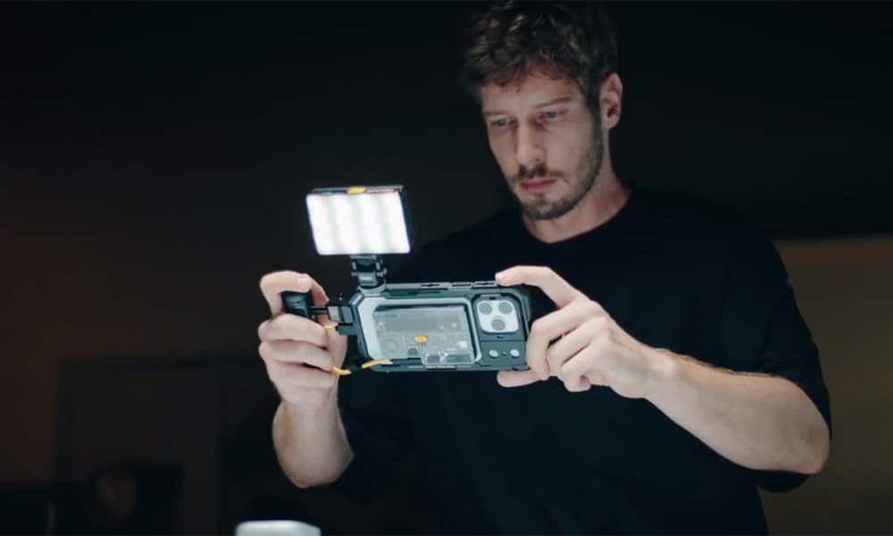 SHARGE Disk Pro 2 clipped to the back of a phone in a handheld video rig with an LED panel light on top