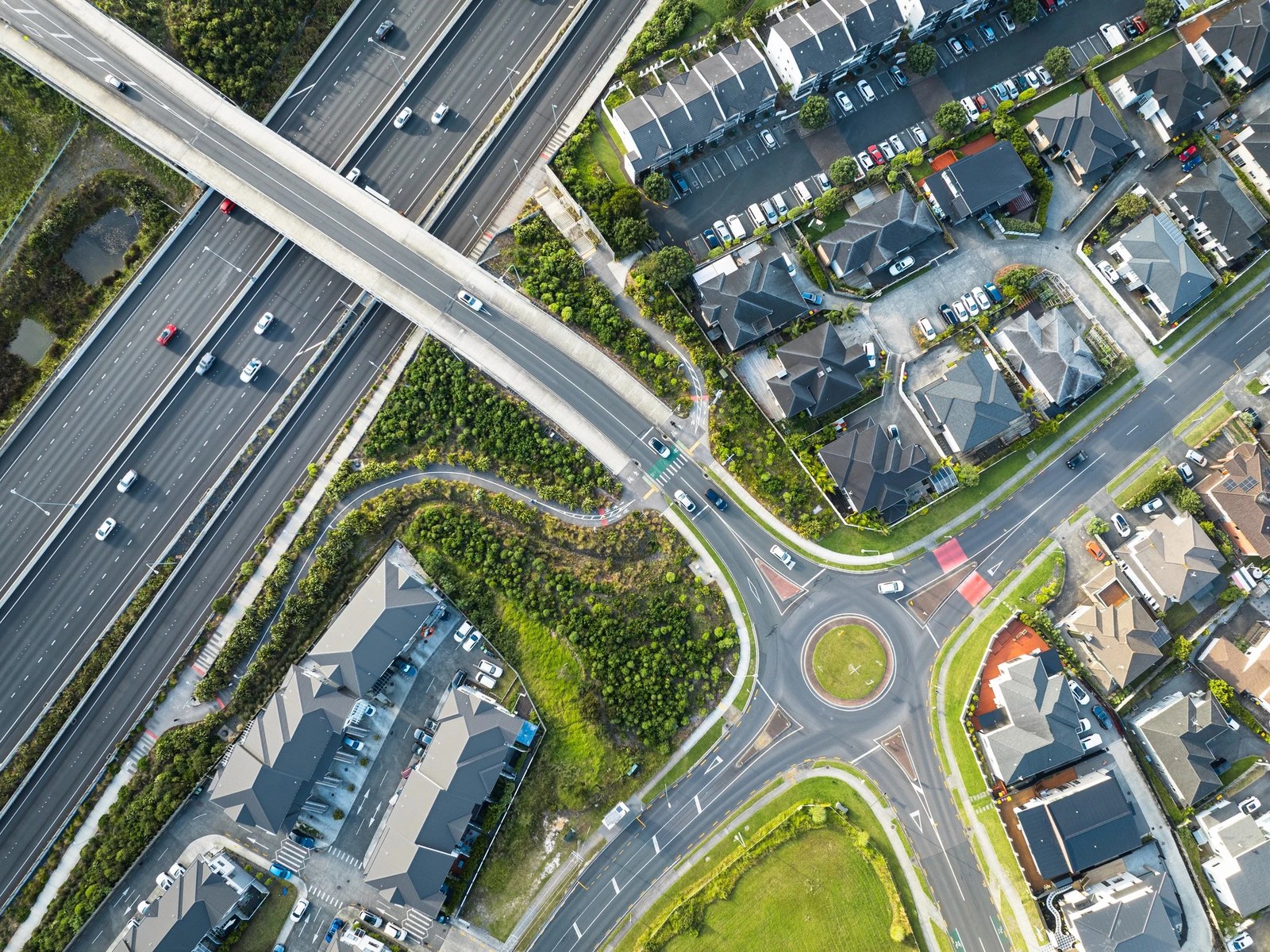 Aerial view of a motorway interchange running past a new suburban housing estate