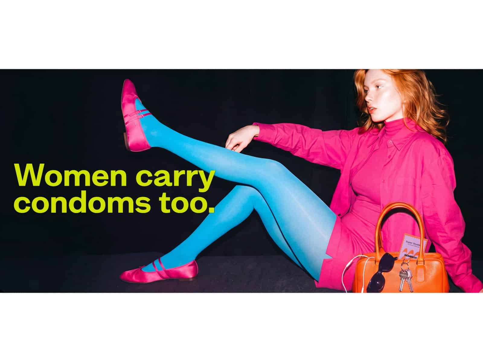 Moments campaign banner reading Women carry condoms too with a woman in pink seated beside a handbag