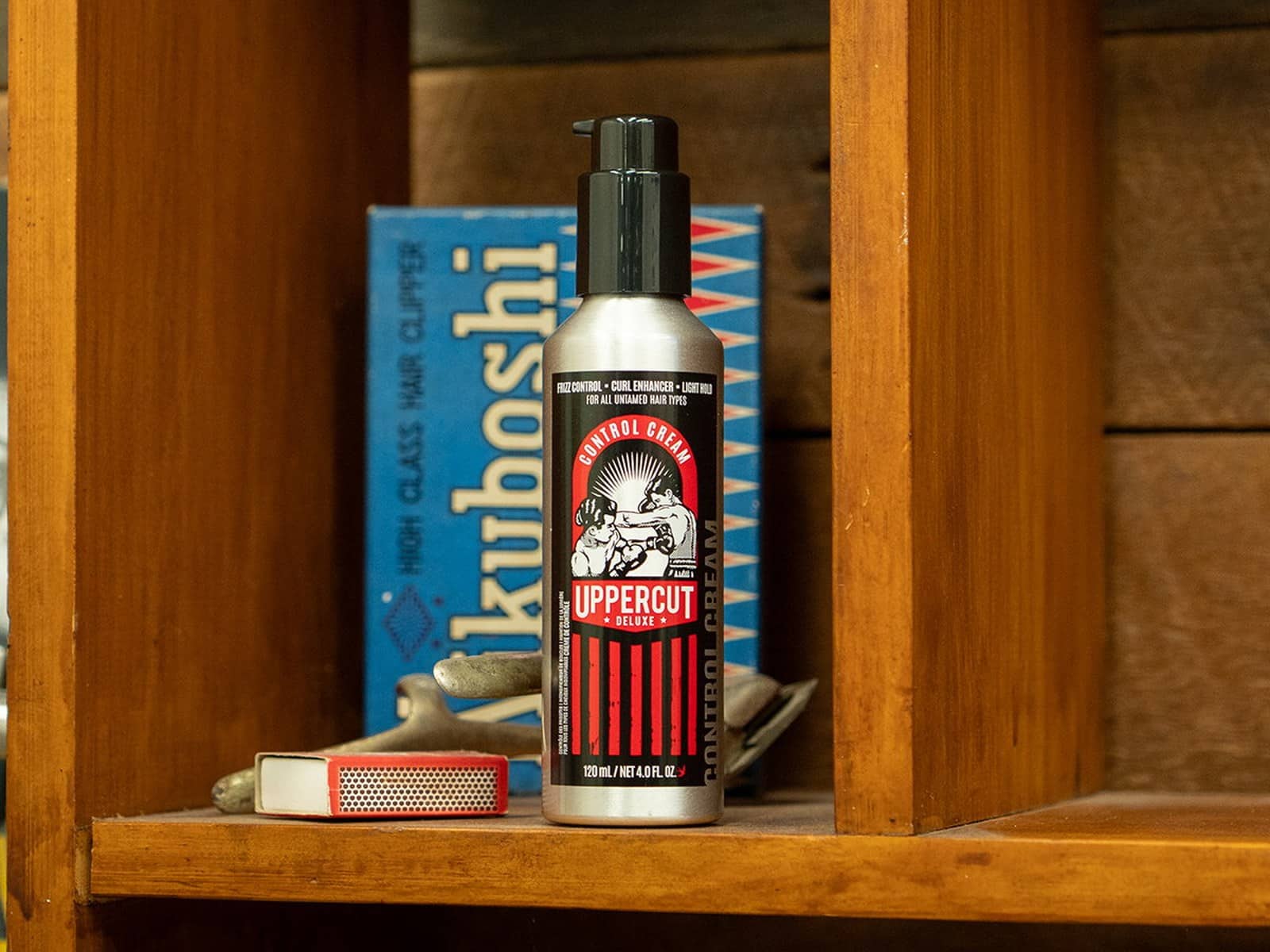 The Control Cream bottle on a timber shelf beside a vintage Kikuboshi hair clipper box and a box of matches.