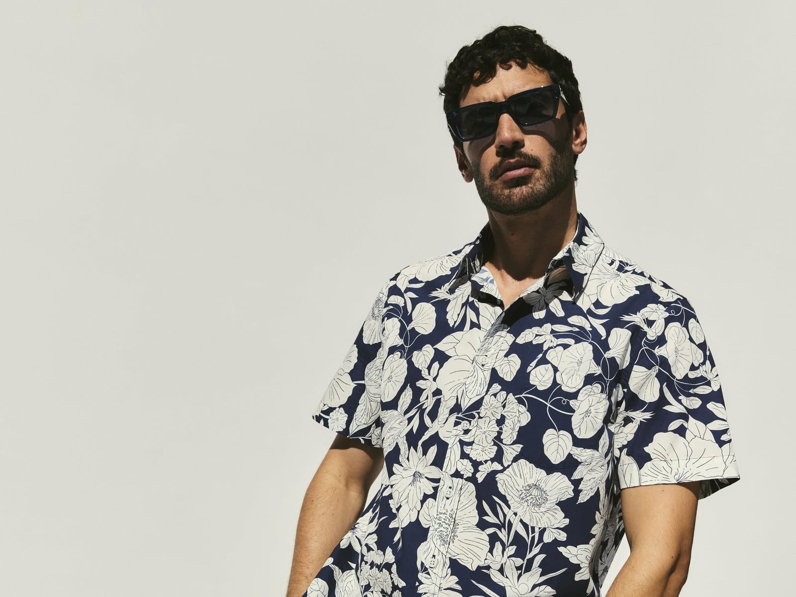 A man in sunglasses wearing the Sportscraft Gardner Short Sleeve Print Shirt in Navy with navy pants