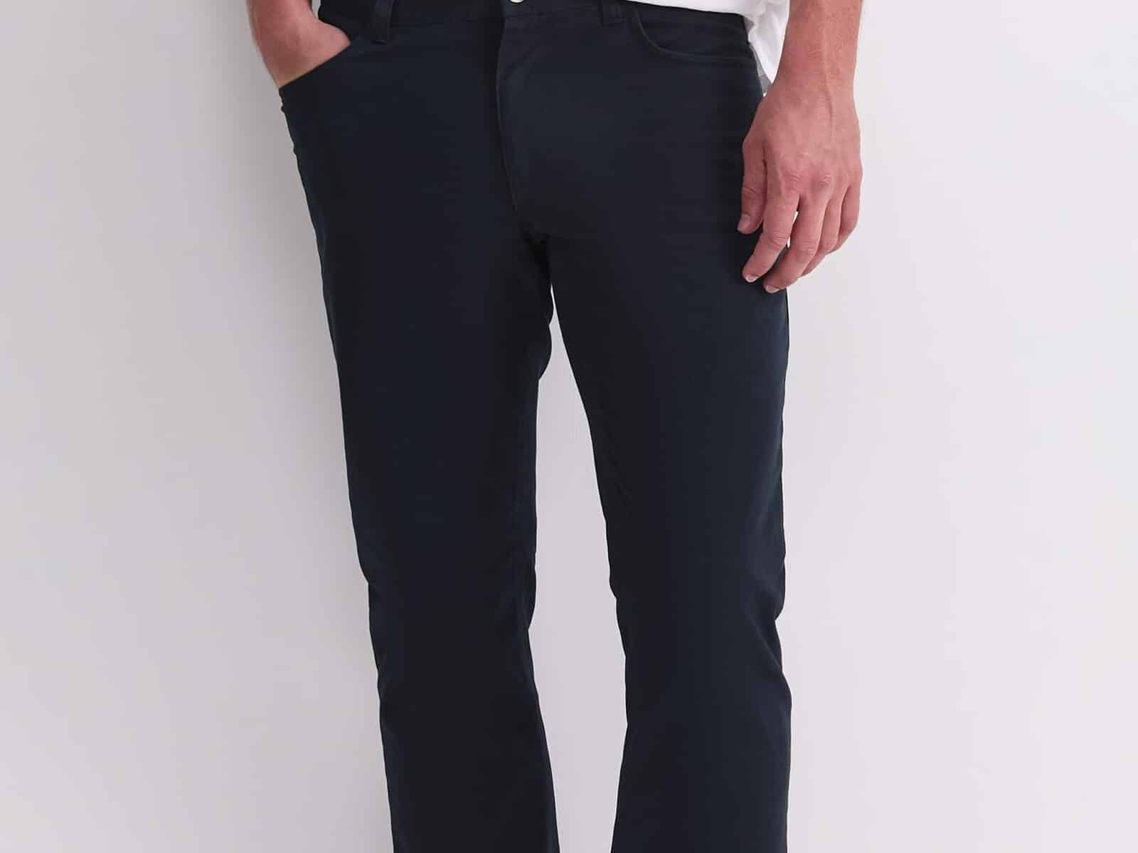 A man wearing the Sportscraft Bedford Jean in French Navy with a white tee and white sneakers