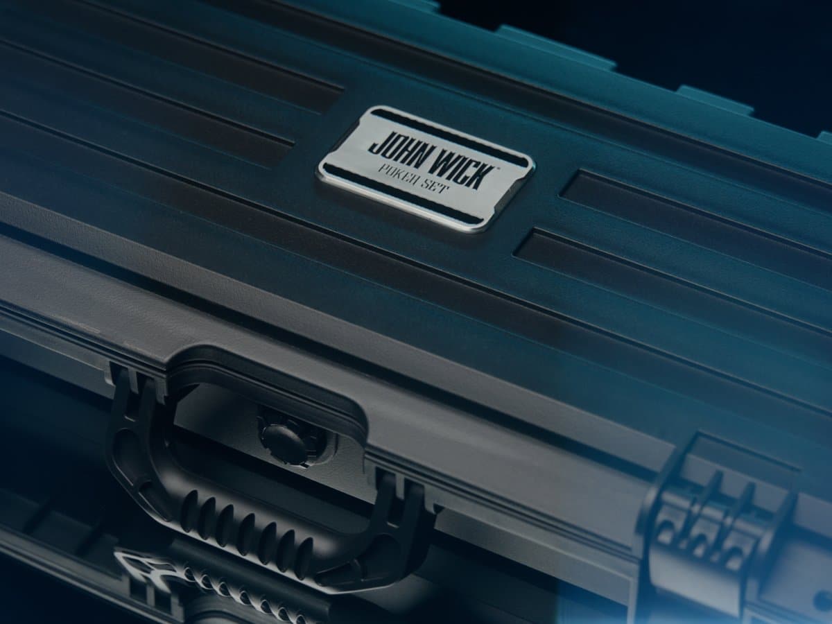 The closed black hard case of the John Wick Poker Set with a metal John Wick Poker Set badge on the lid