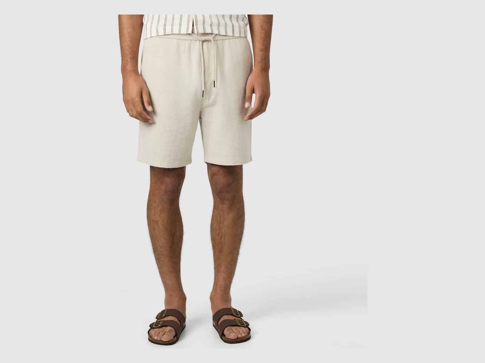 The Connor Cheston Linen Blend Short in Sand worn with a striped shirt and brown slide sandals