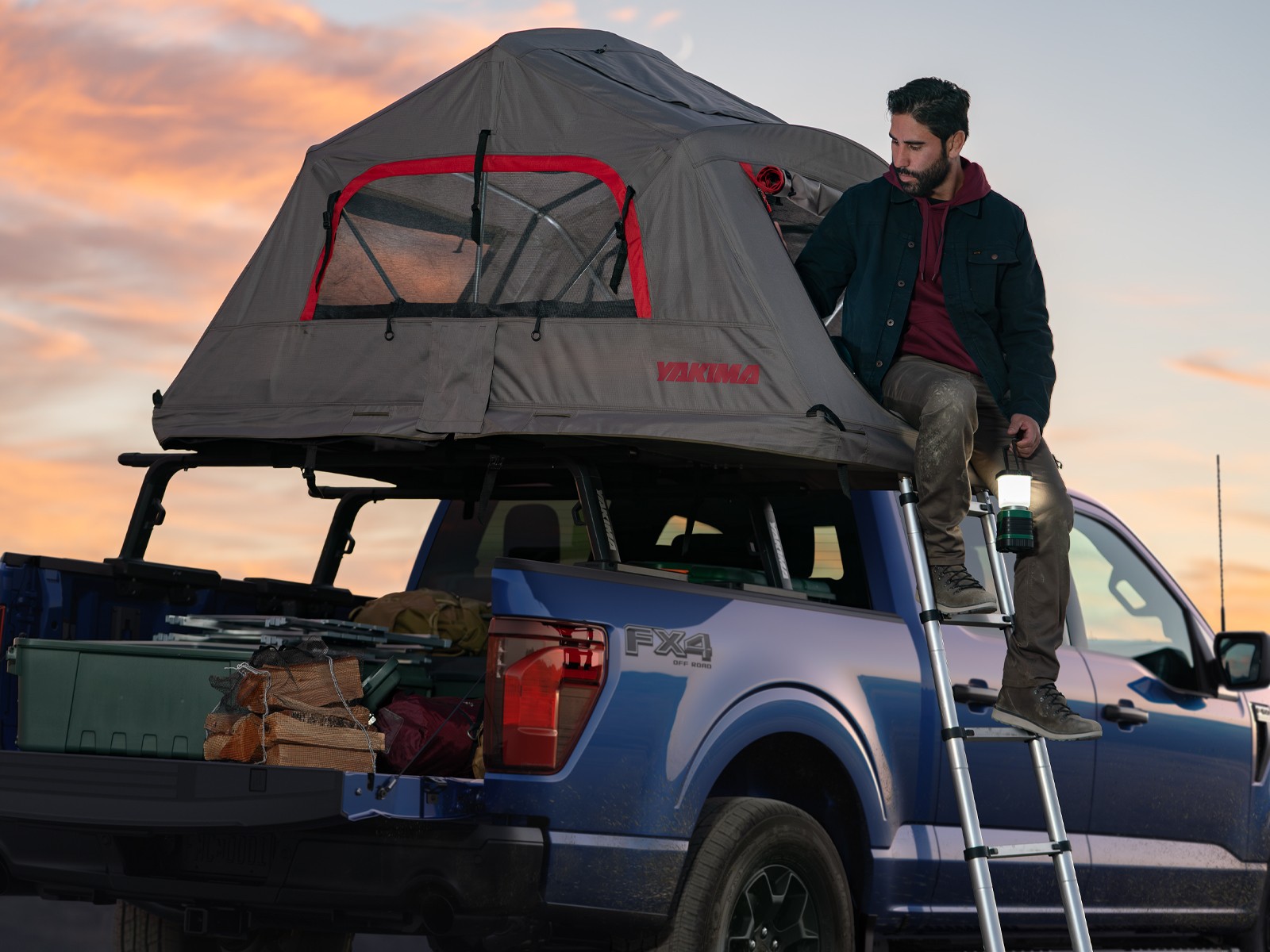 Ford F-150 with a rooftop tent and ladder at sunset